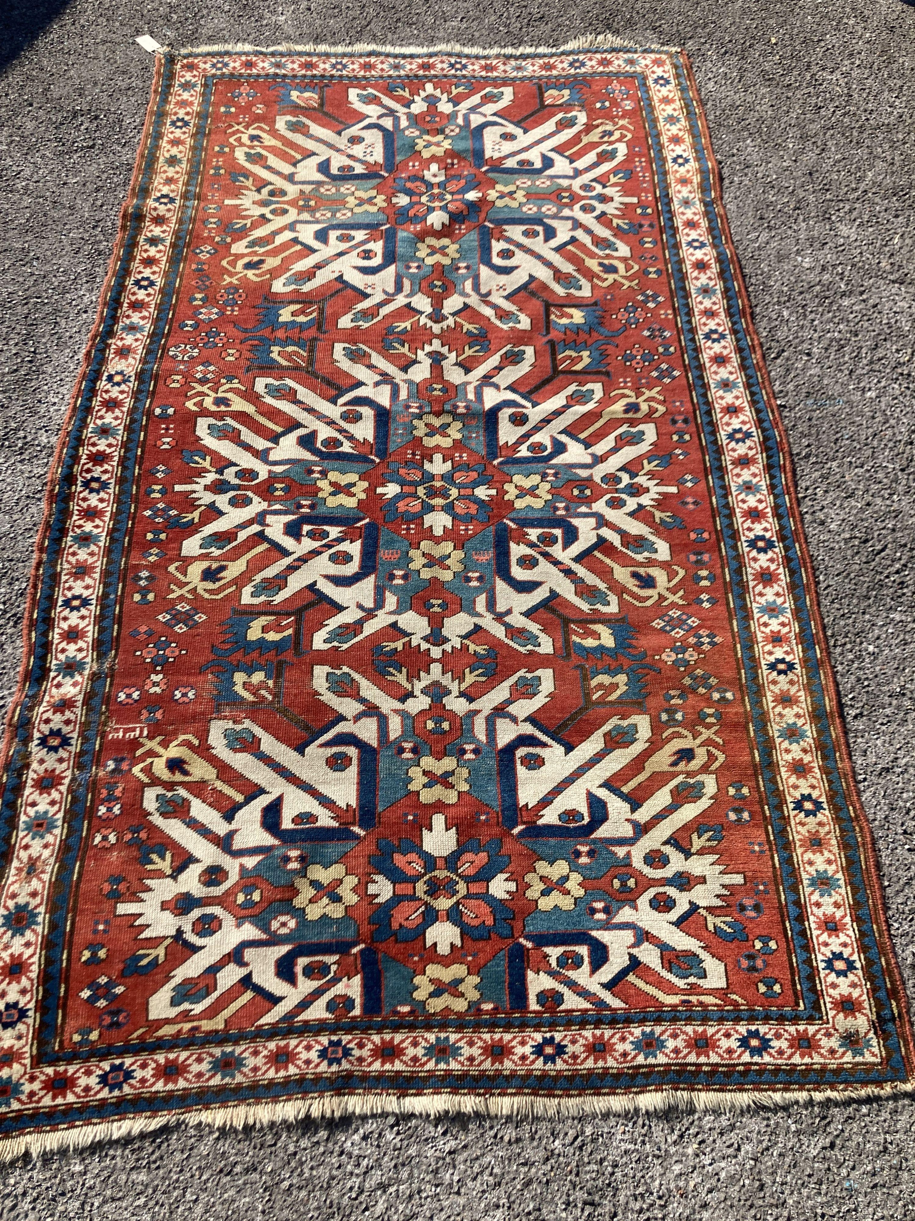 An early 20th century Caucasian “Eagle” Kazak brick red ground rug with triple medallion (altered) 230 x 134 cms.